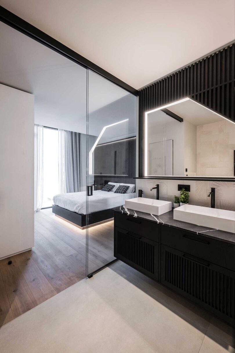 angled view of modern bedroom with black headboard wall with bed appearing to float with lights radiating from underneath